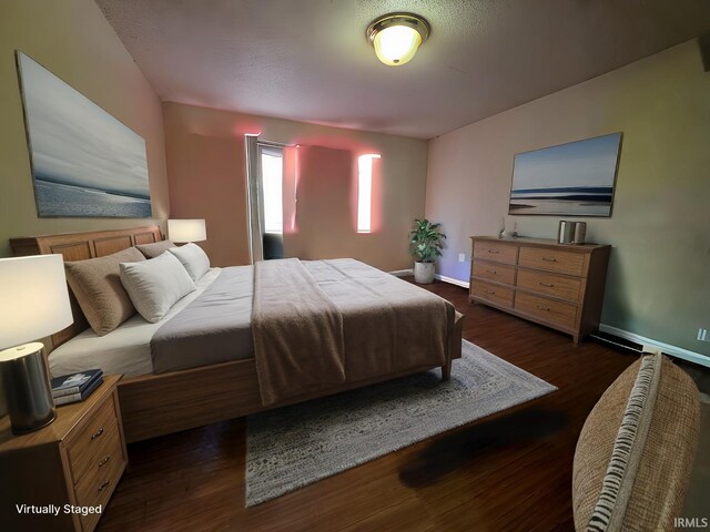 bedroom featuring wood finished floors and baseboards