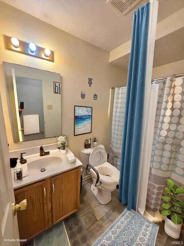 full bath with a textured ceiling, visible vents, a shower with shower curtain, toilet, and vanity