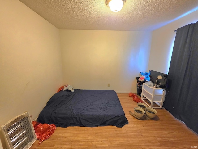 bedroom featuring a textured ceiling, wood finished floors, and visible vents