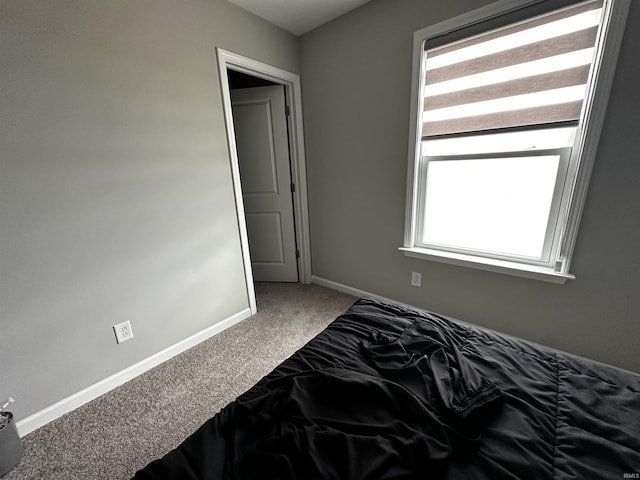 bedroom with baseboards and carpet