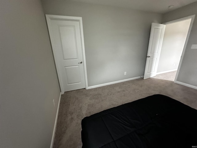 unfurnished bedroom featuring baseboards and carpet flooring