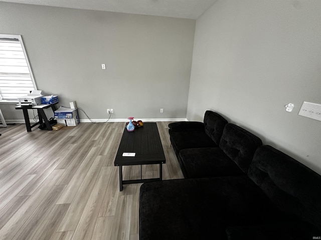 living area with baseboards and light wood finished floors