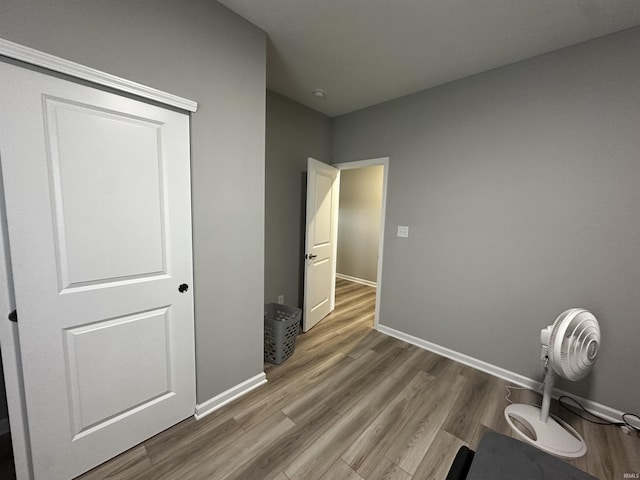 bedroom with wood finished floors and baseboards