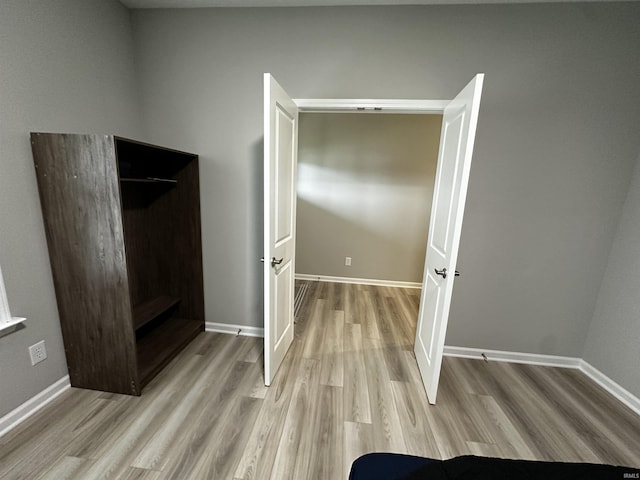 unfurnished bedroom featuring light wood-type flooring and baseboards