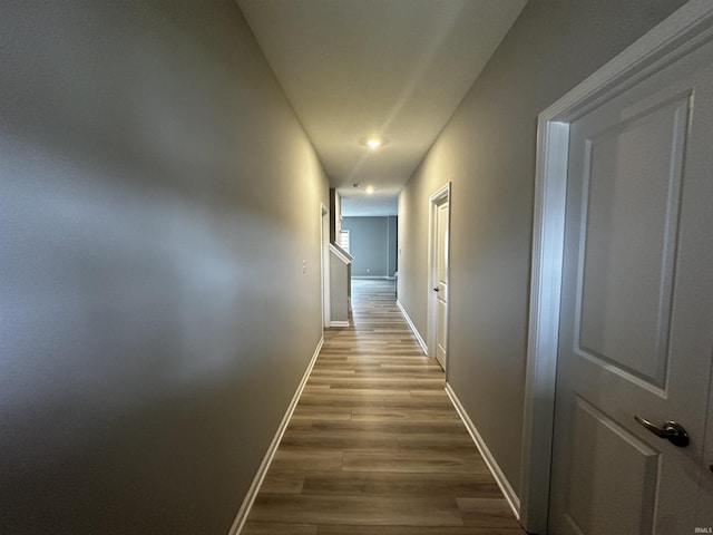 hallway featuring baseboards and wood finished floors