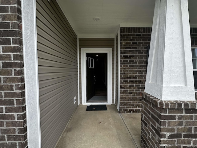 view of exterior entry featuring brick siding