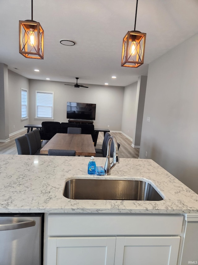 kitchen with a sink, open floor plan, stainless steel dishwasher, and a ceiling fan