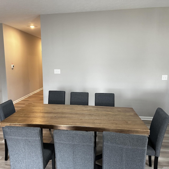dining space with wood finished floors and baseboards