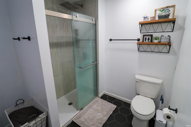 full bathroom featuring a shower stall, baseboards, and toilet