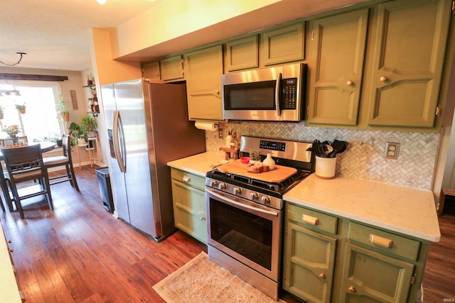 kitchen with dark wood-type flooring, green cabinets, light countertops, and stainless steel appliances