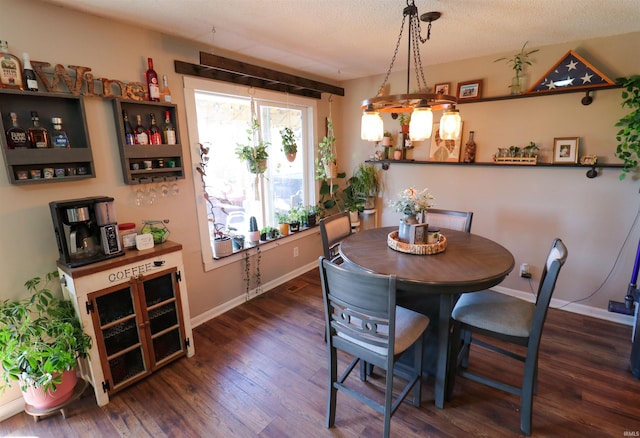 dining space with baseboards, a textured ceiling, and wood finished floors