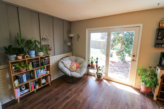sitting room with a textured ceiling and wood finished floors