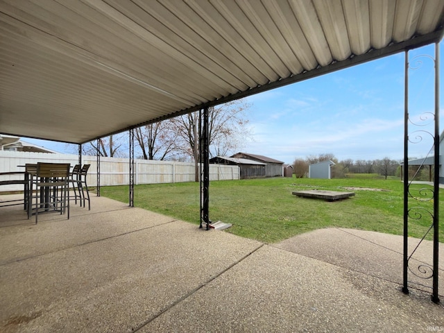 5307 Millersburg Rd, Evansville, IN 47725 - view of patio featuring outdoor dining space, a fenced backyard, a storage unit, and an outdoor structure