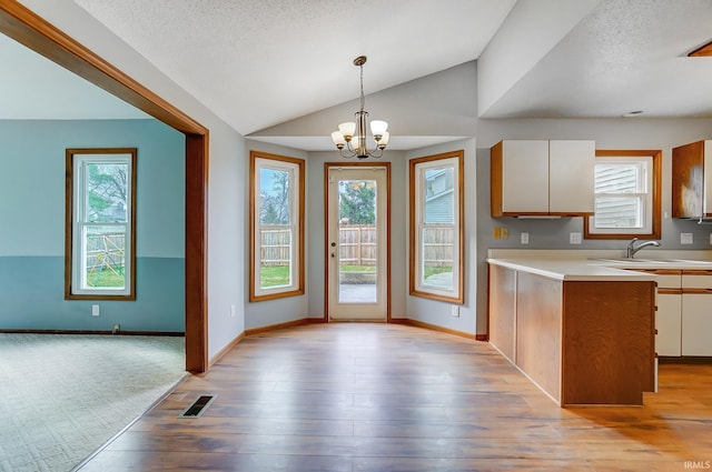 kitchen featuring a chandelier, visible vents, light countertops, and a wealth of natural light