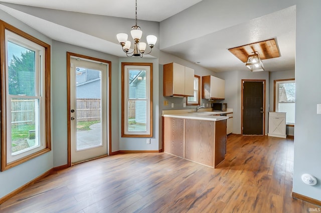 kitchen featuring a peninsula, light countertops, a wealth of natural light, and light wood-style floors