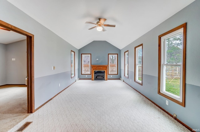 unfurnished living room featuring plenty of natural light, a ceiling fan, and carpet floors