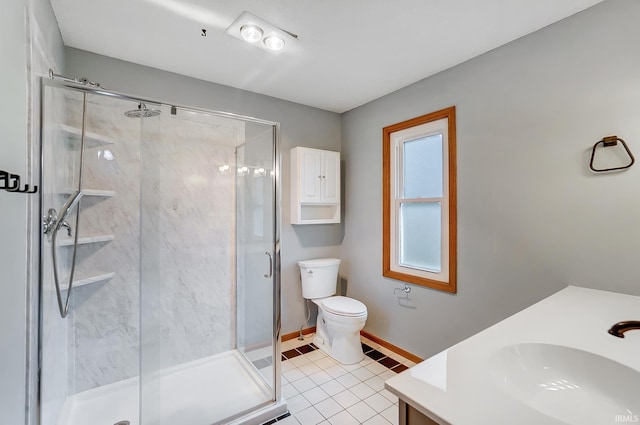bathroom featuring toilet, vanity, baseboards, and a stall shower
