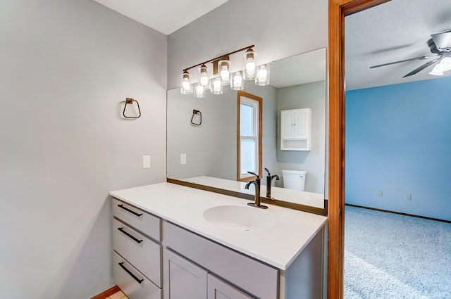 bathroom featuring vanity, baseboards, toilet, and ceiling fan