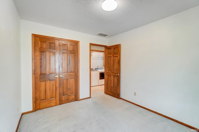 unfurnished bedroom with a closet, baseboards, light carpet, and a textured ceiling