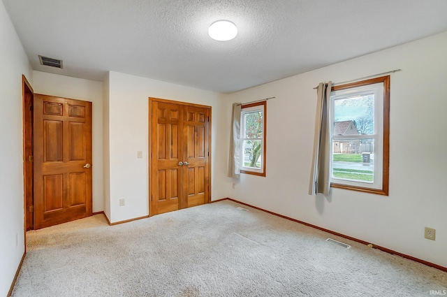 unfurnished bedroom featuring visible vents, baseboards, a closet, and carpet flooring