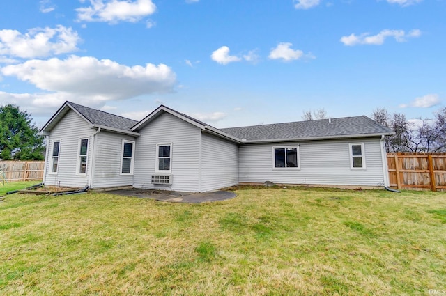 rear view of property featuring a yard, fence, and roof with shingles