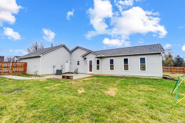 rear view of property with a patio, a yard, fence, and roof with shingles