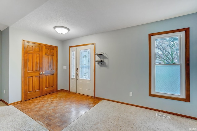 entryway featuring visible vents, baseboards, and a textured ceiling