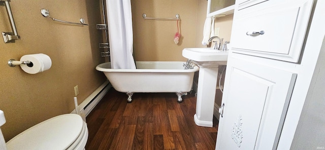 126 E 4th St, Mount Carmel, IL 62863 - bathroom featuring toilet, a baseboard radiator, a freestanding tub, and wood finished floors
