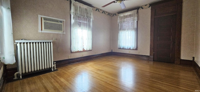 126 E 4th St, Mount Carmel, IL 62863 - empty room featuring wood finished floors, radiator heating unit, baseboards, and a ceiling fan