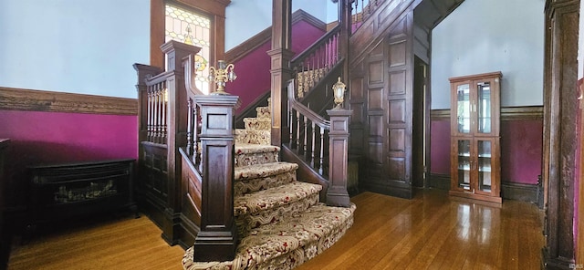 126 E 4th St, Mount Carmel, IL 62863 - staircase featuring a wainscoted wall, a towering ceiling, and wood finished floors