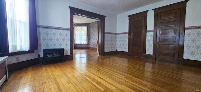 126 E 4th St, Mount Carmel, IL 62863 - unfurnished living room with light wood-style flooring, wallpapered walls, and wainscoting