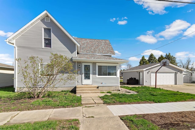 view of front of house featuring a shingled roof, an outbuilding, and a garage