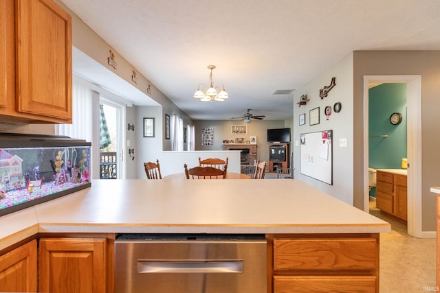 kitchen featuring visible vents, open floor plan, light countertops, a peninsula, and ceiling fan with notable chandelier