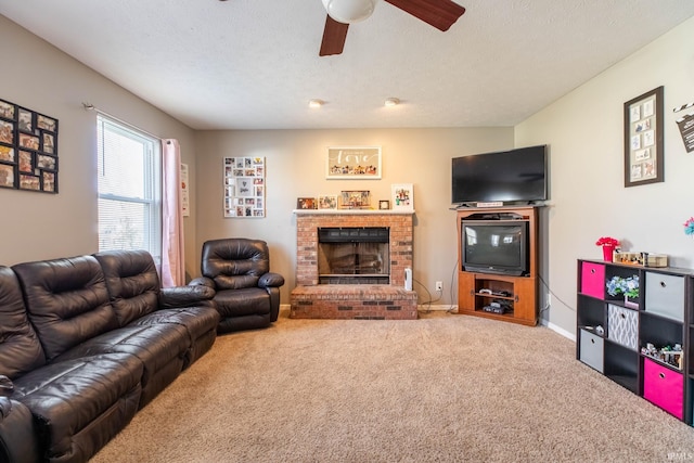 living area featuring a brick fireplace, carpet floors, a textured ceiling, and ceiling fan