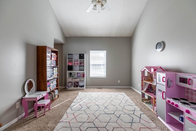 playroom with baseboards, carpet floors, vaulted ceiling, and ceiling fan
