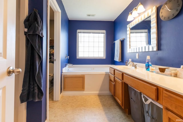 full bathroom featuring visible vents, a garden tub, toilet, and a healthy amount of sunlight