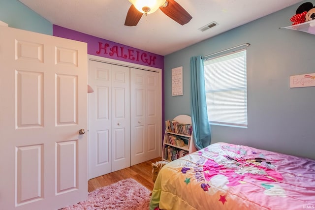 bedroom with visible vents, ceiling fan, a closet, and wood finished floors