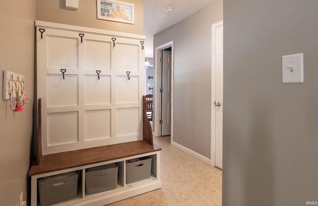mudroom featuring baseboards and light floors