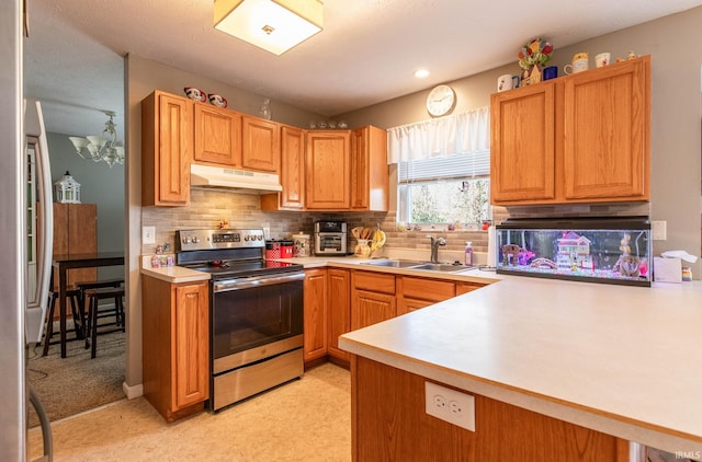 kitchen featuring a sink, light countertops, under cabinet range hood, stainless steel range with electric cooktop, and decorative backsplash