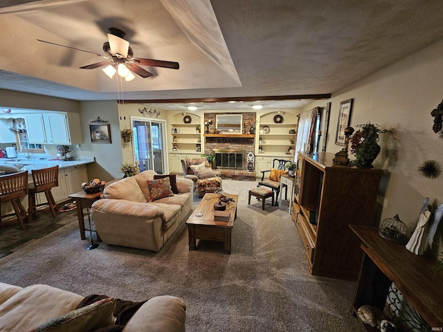 501 Monticello Dr, Vincennes, IN 47591 - living room featuring built in features, a fireplace, a tray ceiling, ceiling fan, and carpet