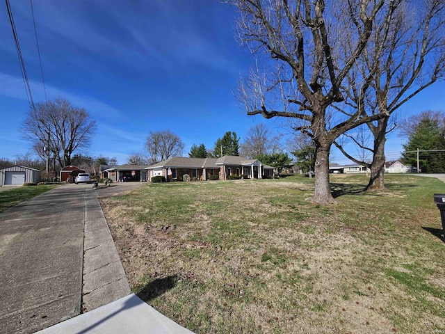 501 Monticello Dr, Vincennes, IN 47591 - ranch-style house with a carport, a front lawn, aphalt driveway, an outbuilding, and a garage
