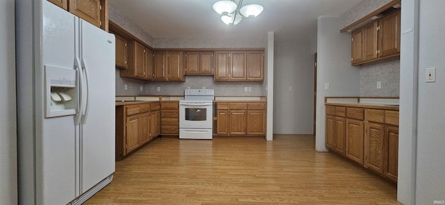 402 Easy St, Mount Carmel, IL 62863 - kitchen with white appliances, light wood-style flooring, tasteful backsplash, light countertops, and a notable chandelier