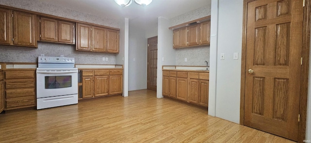 402 Easy St, Mount Carmel, IL 62863 - kitchen featuring white electric range oven, tasteful backsplash, light wood-type flooring, a sink, and light countertops