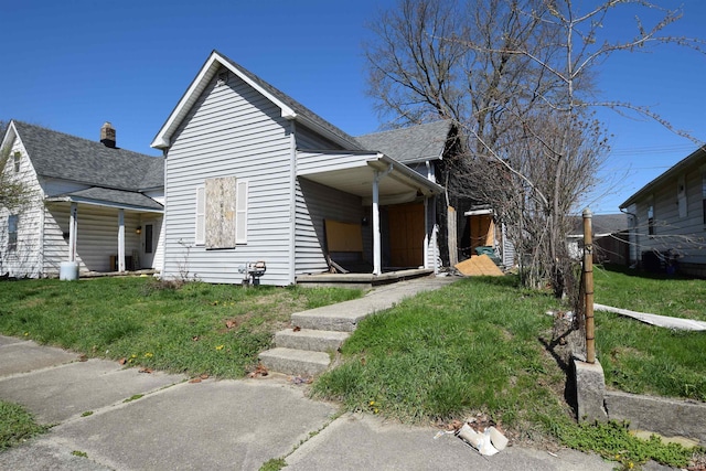 bungalow featuring a front yard and roof with shingles