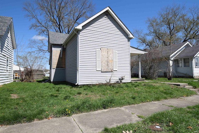 view of home's exterior with a yard and a shingled roof