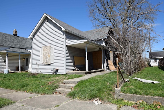 1720 W 7th St, Muncie, IN 47302 - bungalow-style home with a front yard and roof with shingles
