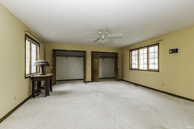 411 S County Road 550 E, Selma, IN 47383 - unfurnished bedroom featuring light colored carpet, baseboards, two closets, and ceiling fan