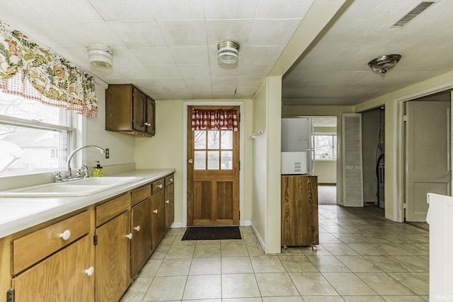 411 S County Road 550 E, Selma, IN 47383 - kitchen with visible vents, light tile patterned flooring, light countertops, a sink, and baseboards