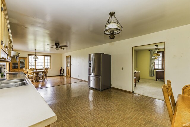 411 S County Road 550 E, Selma, IN 47383 - kitchen featuring a ceiling fan, light countertops, a sink, stainless steel fridge, and hanging light fixtures