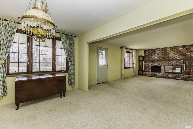 411 S County Road 550 E, Selma, IN 47383 - carpeted living area featuring a notable chandelier, brick wall, and a fireplace